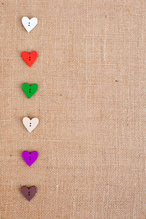 background - natural color burlap hessian with heart shape buttonsの写真素材