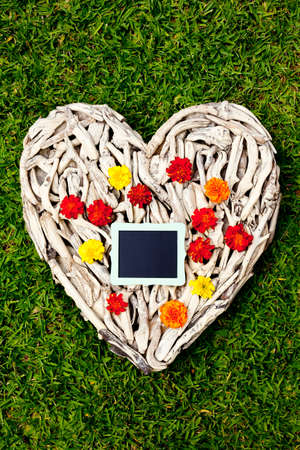 Driftwood Heart on grass background - with blackboardの写真素材
