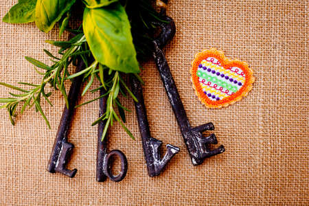 Love Keys with herbs and heart on burlap backgroundの写真素材