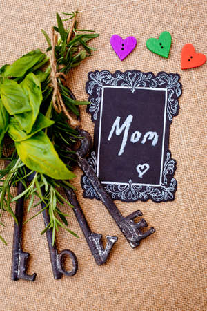 Mother's Day - Mom with love keys on burlap background and heart shaped buttonsの写真素材