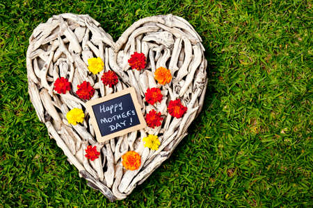 Happy Mother's Day - driftwood heart on grass backgroundの写真素材