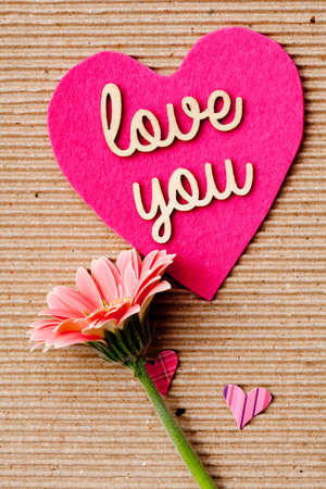 Love You - Be my valentine with pink hearts and flower on corrugated paper backgroundの写真素材