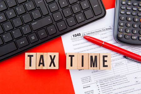 Tax Time - USA - wooden letters with 1040 Tax Form, keyboard and calculatorの写真素材