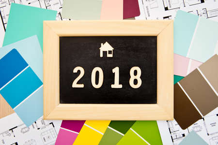 2018 in wooden letters on blackboard with house icon, samples and house drawings