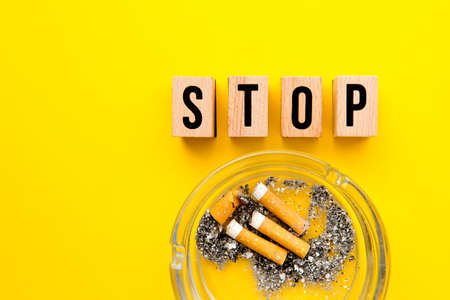 Stop Smoking - block wooden letters with ashtray on yellow backgroundの写真素材