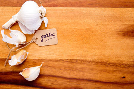 Garlic Cloves with label on wooden cutting boardの写真素材