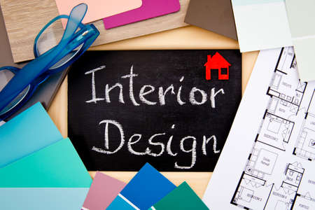Interior Design handwritten on blackboard with house drawings, samples and eyeglassesの写真素材