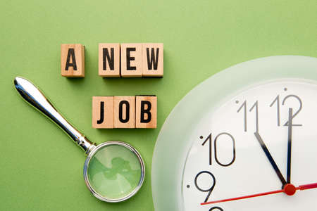 Time for a new Job - wooden block letters with clock face and magnifying glassの写真素材