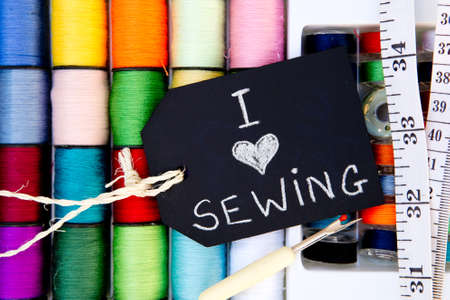 I love Sewing - colorful cotton reels background with blackboard and tape measure and unpickerの写真素材