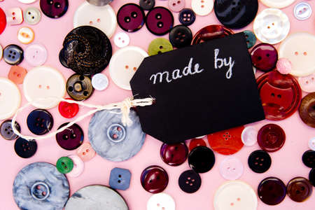 Sewing - Made By blackboard with buttons on pink backgroundの写真素材