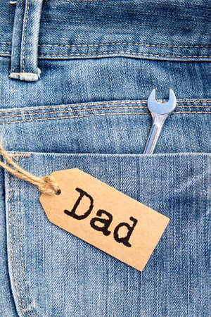 Dad tag on blue denim background with tool in pocketの写真素材