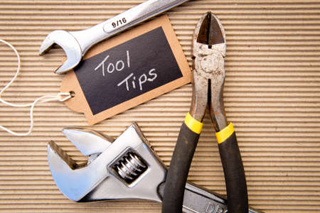 background - selection of tools on corrugated cardboard background with Tool Tips tag