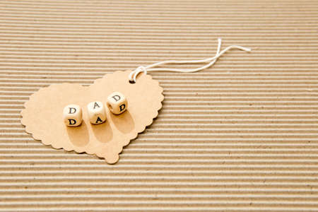 Father's Day - Dad on cardboard heart on corrugated cardboard backgroundの写真素材
