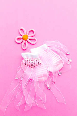 Baby Girl announcement background - pink and white socks with flower on pink backgroundの写真素材