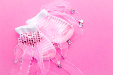 Baby Girl announcement background - pink and white socks with lace on pink backgroundの写真素材