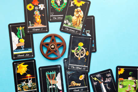 Tarot readings with deck of Tarot cards with wooden pentagram incense burner on blue backgroundの写真素材