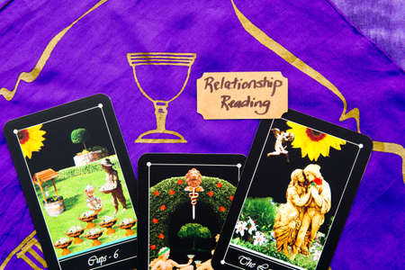 Tarot Relationship readings with deck of Tarot cards on purple silk reading cloth with gold patternの写真素材
