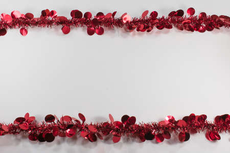 Red decorative tinsel forming a border on the top and bottom  with copy space