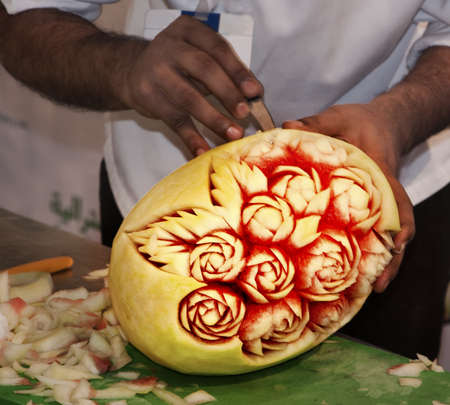 A chef in action carving the water melon, duing the Gulf Food Festival in Dubai.の写真素材