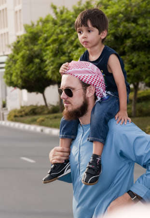 DUBAI - UAE - APRIL 06 2012: A Imam of Dubai Mosque with his son aged 3 during the "March For Peace" event organized by Dubai Islamic Department and Govt. of Dubai on April 06 2012 in Zabeel, Dubai.のeditorial素材