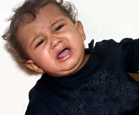 Young Indian baby boy crying in pain. 