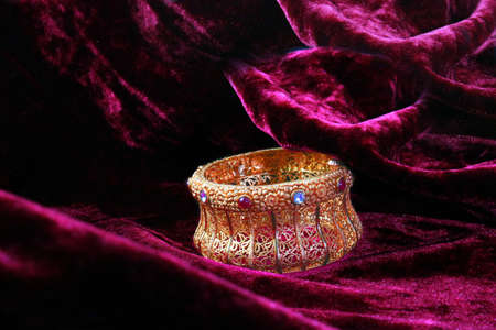 big gold hand bracelet with purple backgroundの写真素材