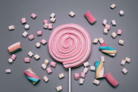 Marshmallows and lolly pop on the grey background.の写真素材