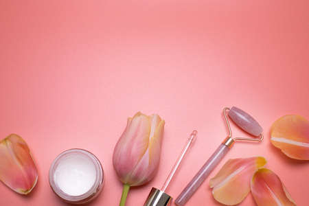 Beauty background with facial cosmetic products and petals, with free space for text.の写真素材
