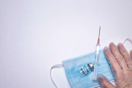 COVID-19 Vaccine and mask on the white background. Healthcare and medical concept. Free space for...