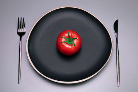 Tomato on the black plate. The concept of diet.の写真素材
