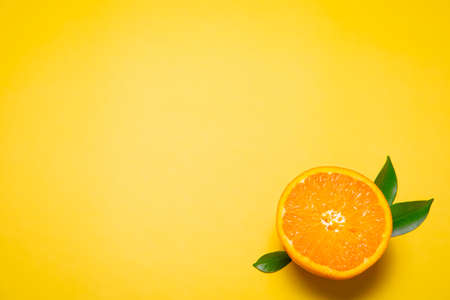 Orange on the yellow background. Free space for text.の写真素材