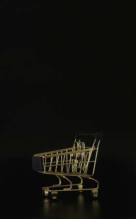 Shopping trolley on the black background with free space for text. Black friday concept. Sale, deal and discount. Closeup, copy space.の写真素材