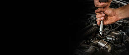 Auto mechanic working on car engine in mechanics garage. Repair service. Close-up shot. Free space for text, copy spaceの写真素材