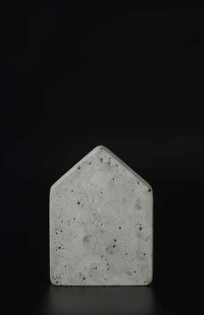 Mini concrete house model on the black background. Buy a house. Concept for property ladder,...
