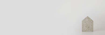 Mini concrete house model on the white background. Buy a house. Concept for property ladder, mortgage and real estate investment. Free space for text, copy space, modern layout.の写真素材