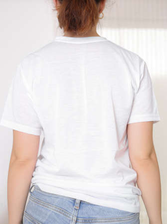 Female model wearing a white t-shirt, back view. T-shirt mockup, template for picture, text . Free space, copy space.の写真素材