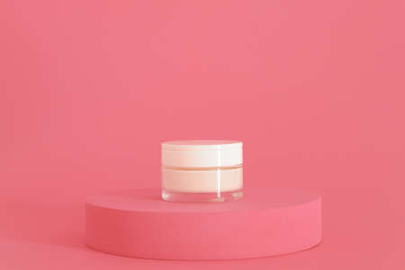 Cosmetic cream packaging standing on pink podium. Cream presentation on the pink background. Mockup.の写真素材