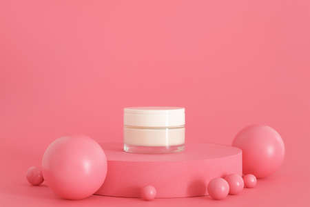 Cosmetic cream packaging standing on pink podium. Cream presentation on the pink background. Mockup.の写真素材