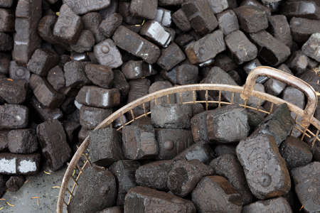 Closeup view of black charcoal, coal briquets. Energy resource, heating, industrial use.