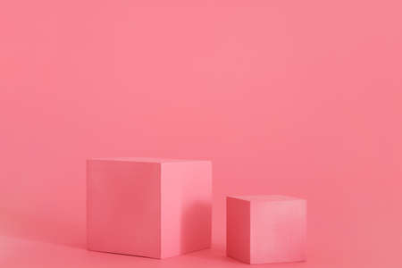 Two pink podiums on the pink background. Podium for product, cosmetic presentation. Creative mock up. Pedestal or platform for beauty productsの写真素材