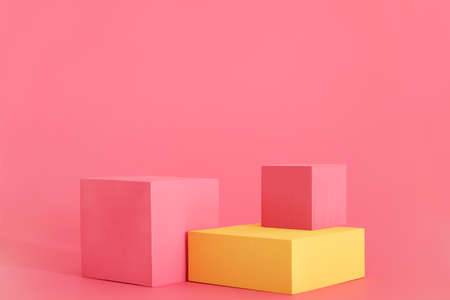 Pink and yellow podium on the pink background. Podium for product, cosmetic presentation. Creative mock up. Pedestal or platform for beauty products.の写真素材