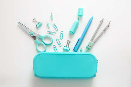 Blue stationery items on the white background. Creative, colorful background with school supplies....