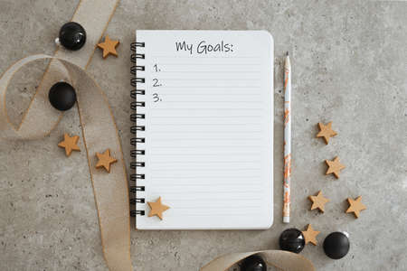 Top view of notebook with Christmas decorations. Goals list for new year. Free space, copy space, mockup or template for your text.の写真素材