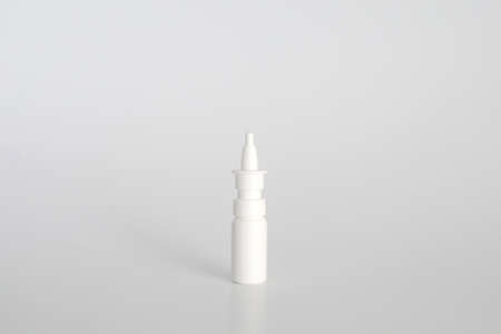 White plastic nasal spray bottle on white background. Nasal spray container, saline water solution...