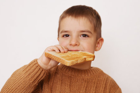 Preschool boy eating toasted bread. Gluten intolerance by children.の写真素材