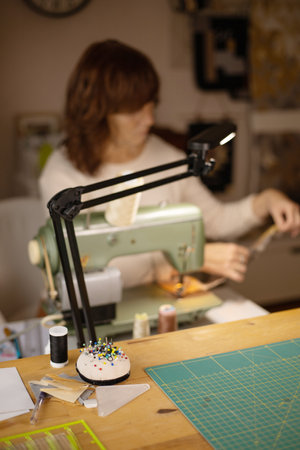 Woman sewing fabric with a vintage, retro sewing machine. Fashion, creation and tailoring. Process...
