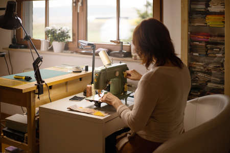 Woman sewing fabric with a vintage, retro sewing machine. Fashion, creation and tailoring. Process...