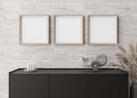 Three empty square picture frames on white brick wall in modern living room. Mock up interior in...
