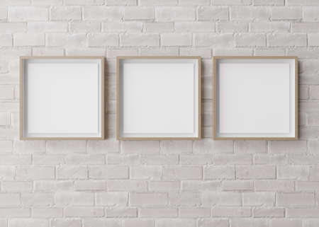 Three blank square picture frames hanging on white brick wall. Template, mock up for your picture or...
