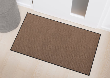 Blank brown door mat on wooden floor, perfect for showcasing custom designs or logos in an urban home setting. Welcome mat with copy space. Doormat mock up. Carpet at entrance. 3D.の写真素材